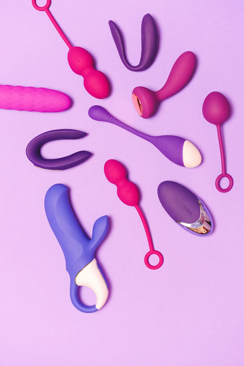 Different erotic toys on a lilac background: tools for self-exploration